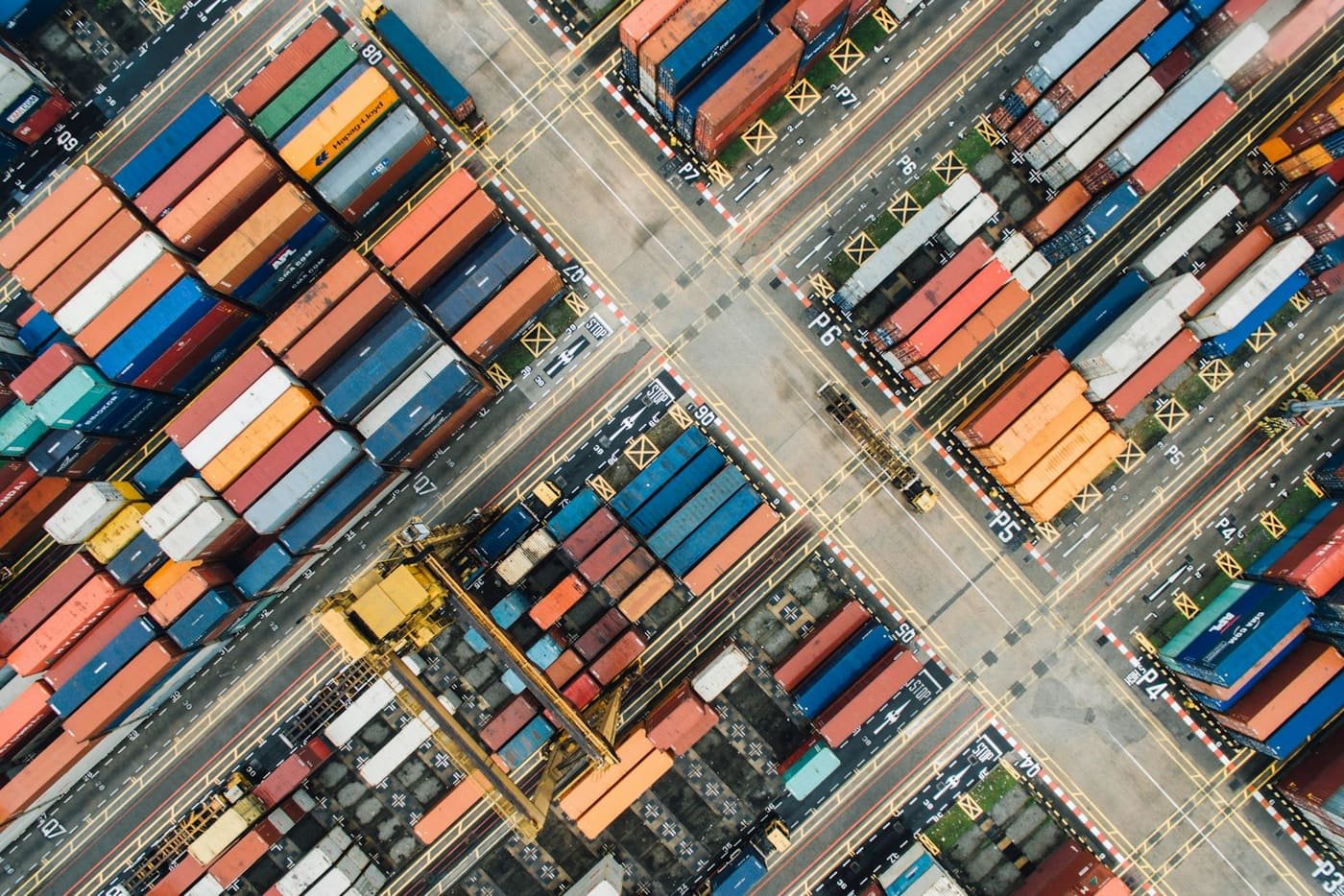 Top-down aerial view of a container yard with stacks of colourful containers