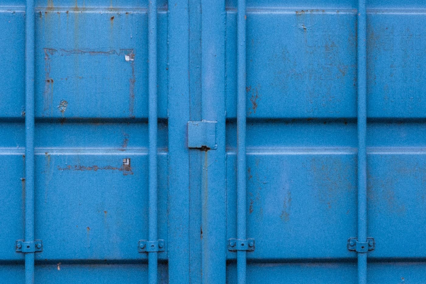 Close-up of the weathered blue door of a shipping container