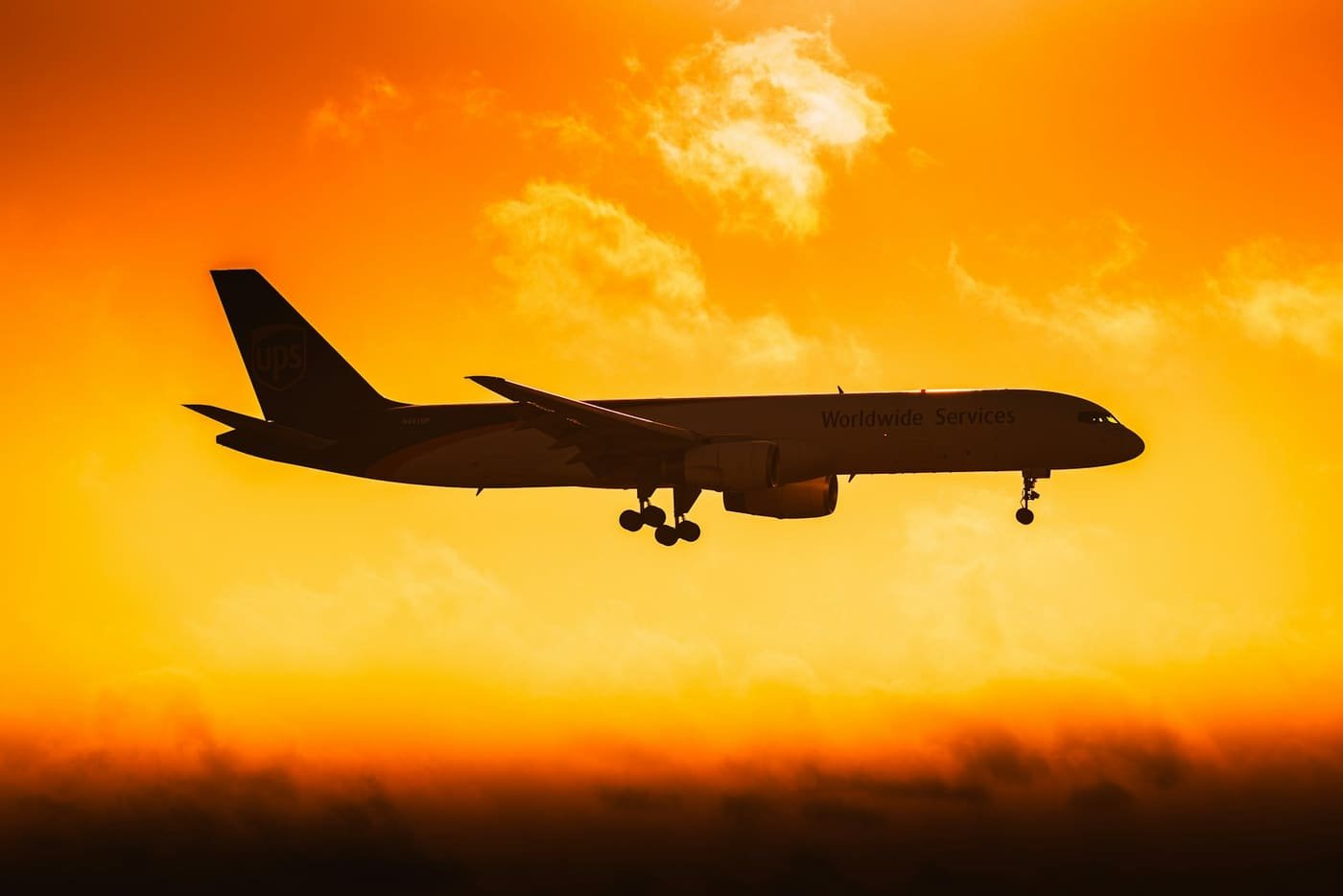 Aircraft silhouetted against an orange sunset sky