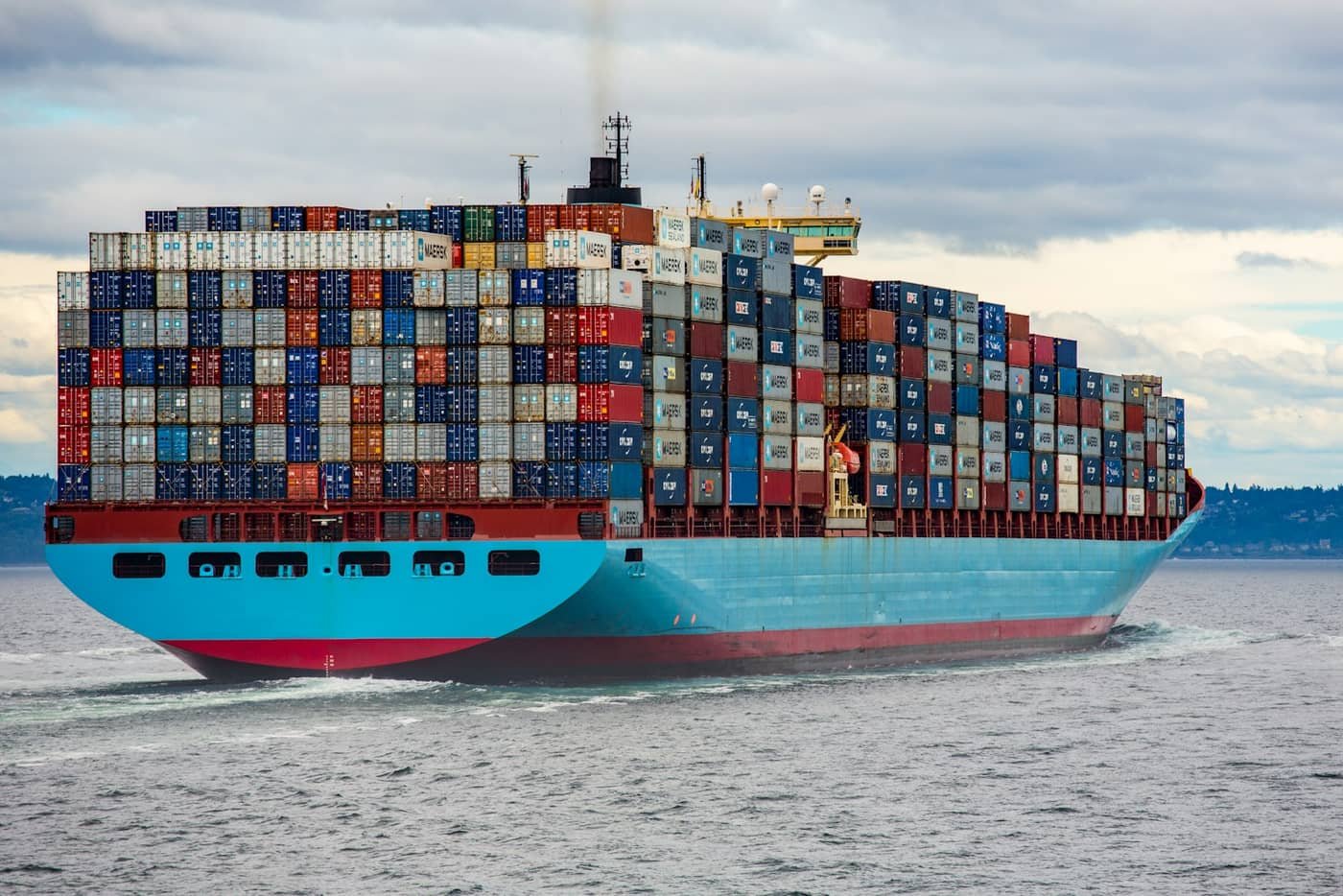 Container ship loaded with stacked containers sailing at sea