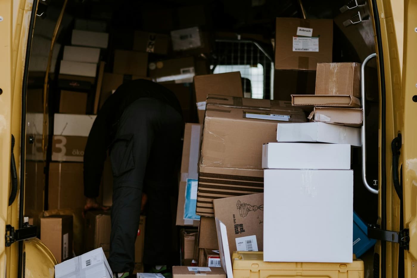 Person loading cardboard boxes into a delivery van