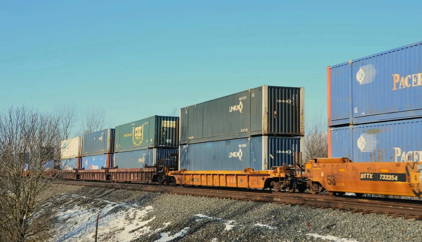 Double-stack freight train carrying shipping containers on a railway line