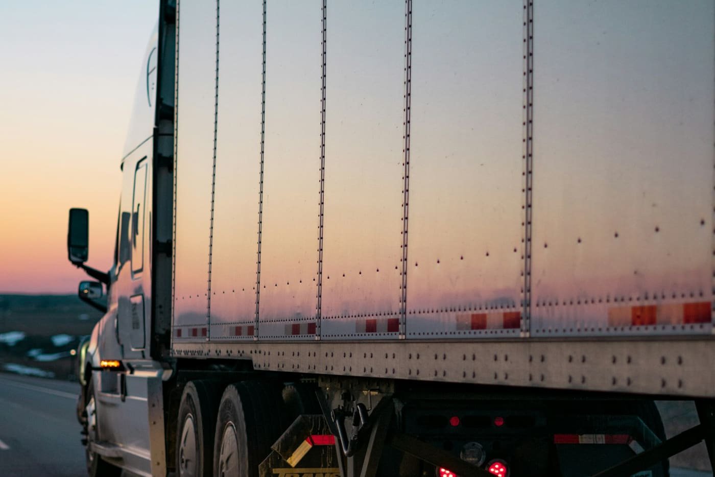 Freight truck and trailer on a road at sunset