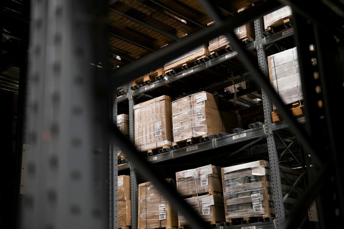 Cartons shrink-wrapped on pallets with barcode labels on warehouse racking