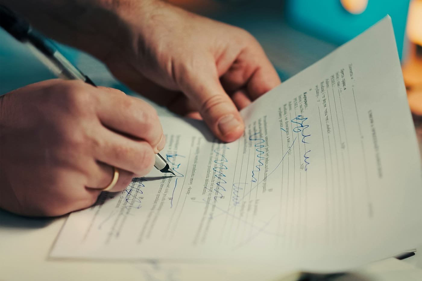 Hand signing a paper document with a pen
