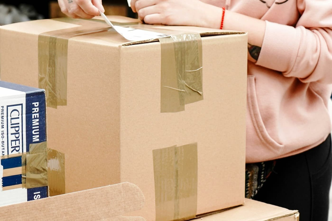 Person taping and labelling a cardboard box