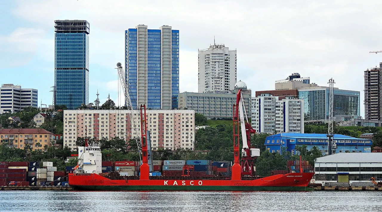 Cargo ship moored at a quay with a city behind it