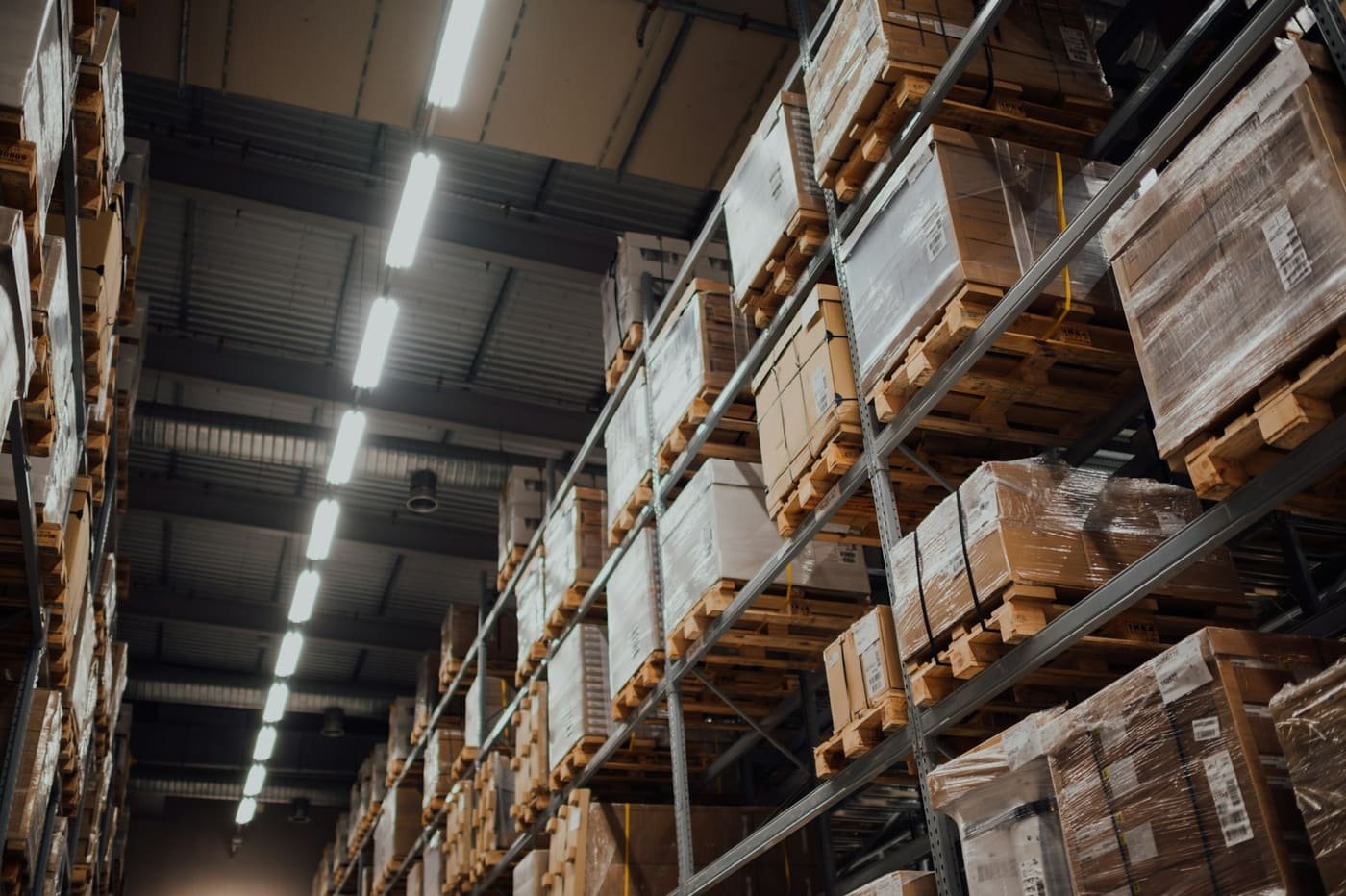 Warehouse aisle with cartons stacked on pallets on metal racking