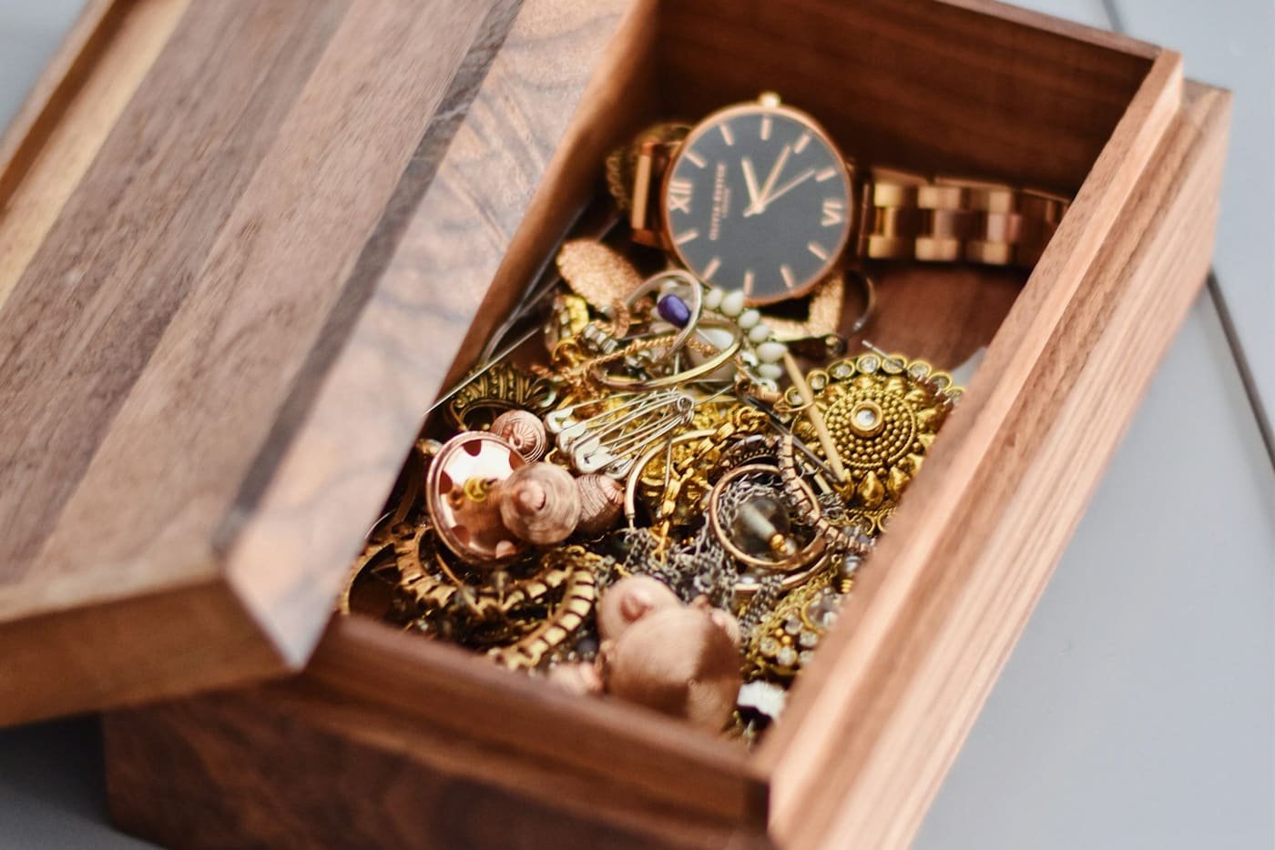 Wristwatch and gold jewellery in a small wooden box