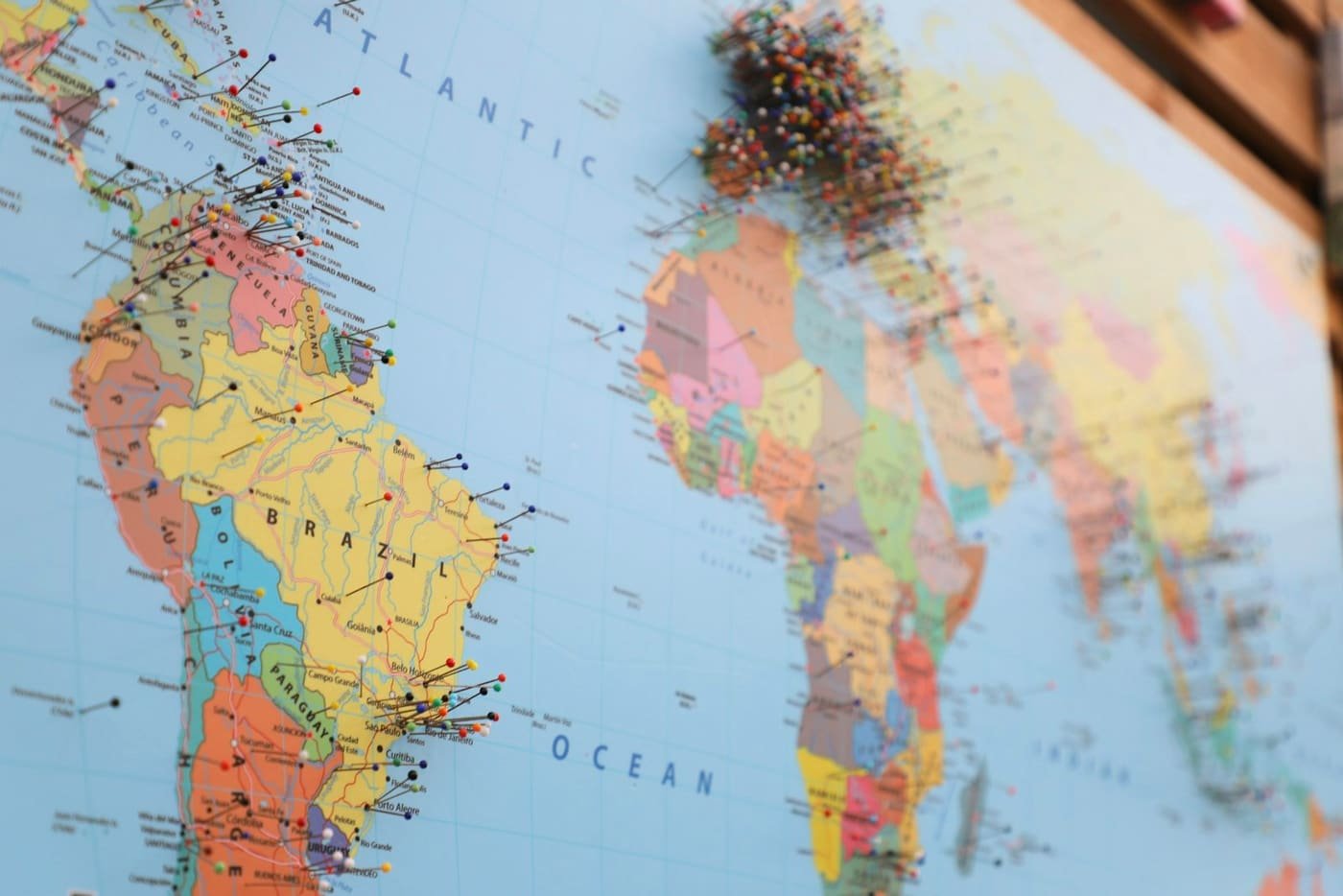 Close-up of a world map with pins marking locations across the Atlantic